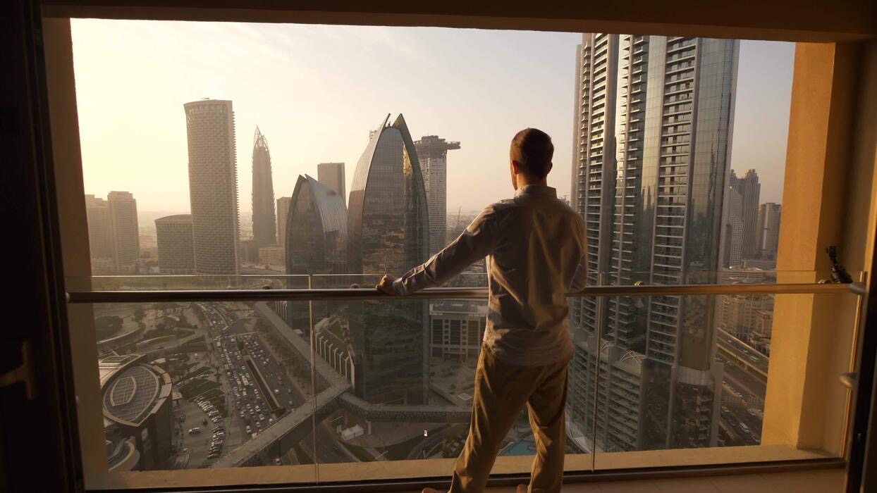 Founder looking over a city skyline at sunrise